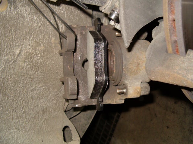 And then place the inner brake pad (with the metal springs into the hole of the caliper piston) into the brake caliper.